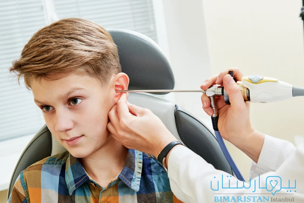 Bir çocuğun kulağını endoskopla inceleyen doktor